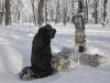 Mulher reza sobre a densa camada de neve que cobre árvores em um parque na cidade ucraniana de Kiev