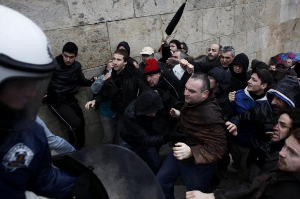 Polícia e manifestantes se enfrentam próximo ao parlamento em Atenas Angelos Tzortzinis/AFP Polícia e manifestantes se enfrentam próximo ao parlamento em Atenas Angelos Tzortzinis/AFP