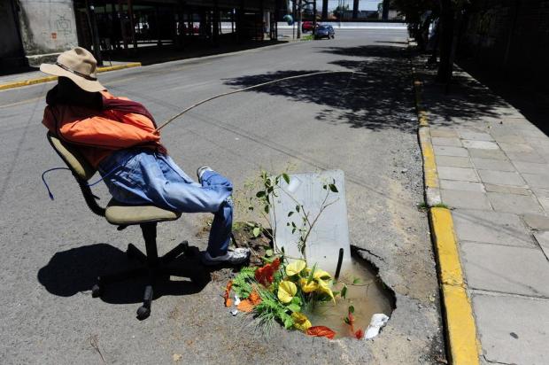 Moradores protestam contra cratera inundada com boneco que imita pescador em Canoas  Ronaldo Bernardi/Agencia RBS