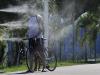 Ciclista se refresca no gasômetro, em Porto Alegre