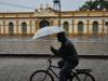 Mesmo inadequado para uso na bicicleta, o guarda-chuva proteje contra a chuva, em Pelotas/RS