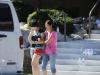 Lin Gan, enxugando as lágrimas, é levada pela mãe, Juan Gan, até o carro, após um encontro entre familiares de vítimas do massacre ocorrido durante a projeção do filme Batman