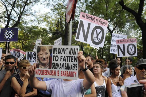 Manifestantes na Espanha protestam contra a visita de Angela Merkel DOMINIQUE FAGET/AFP Manifestantes na Espanha protestam contra a visita de Angela Merkel DOMINIQUE FAGET/AFP