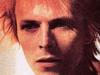 Bowie começa a se reinventar com Space Oddity (1969), seu segundo álbum. Calças justas, brilho e plataformas acompanham o novo cabelo alaranjado do músico  