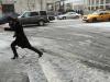 Mulher tenta atravessar a rua coberta pela neve em Nova York
