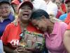 Mulheres choram segurando foto de Chávez em Caracas, na Venezuela