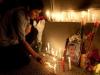 Homem acende velas brancas em frente a embaixada da Venezuela em Santiago, no Chile