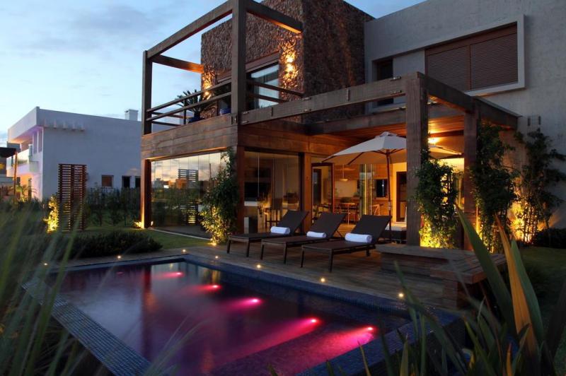 Mas é de noite que a área a céu aberto ganha mais charme. Isso por conta da iluminação embutida na piscina feita com fibra ótica e sistema RGB que ilumina o interior com cores variadas e alternadamente:imagem 13