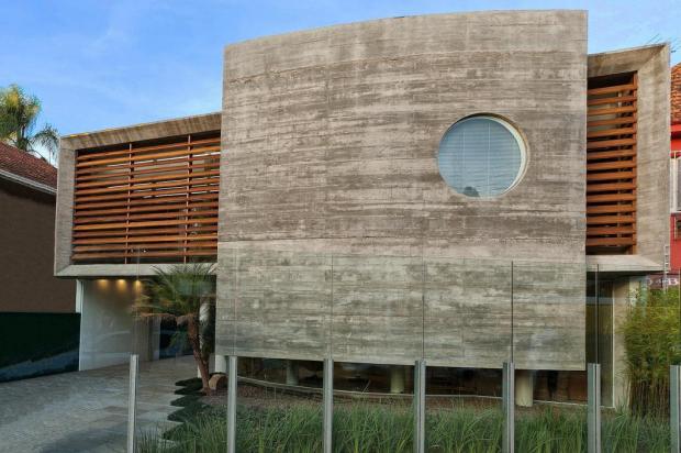 Concreto na fachada de clínica com arquitetura brutalista é suavizado pela madeira e vidros Nattan Carvalho/Divulgação