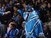 Torcedor se cobre com bandeira do Grêmio