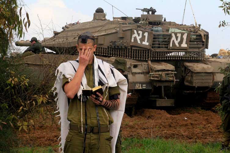 Soldado israelense reza em frente a tanques, nas proximidades de Gaza, nesta terça-feira (30/12):imagem 51
